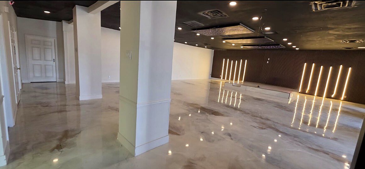 Event hall with white columns and a side corridor leading to the stage