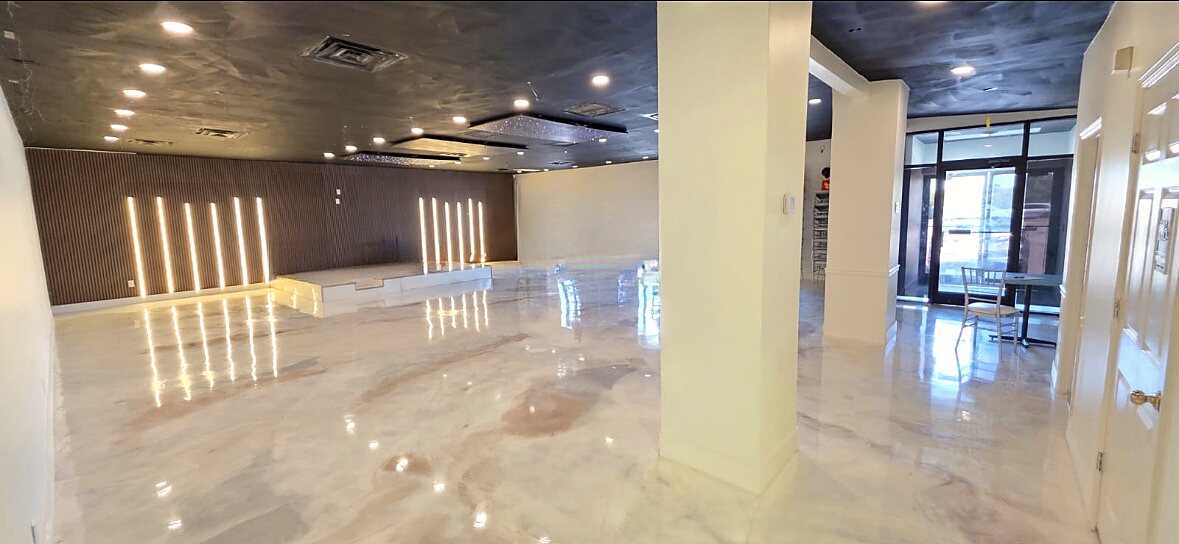 Event hall seen from the entrance, with glass front doors and marble-look floor